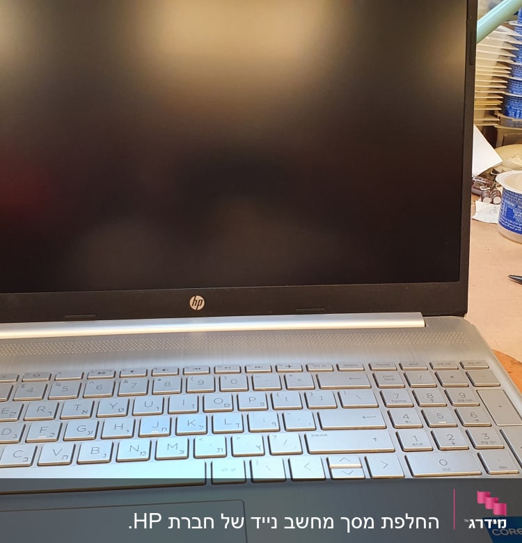 מחשב נייד HP עם מקלדת כסופה על שולחן עבודה